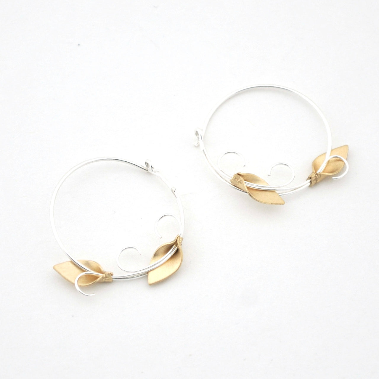 Hoop earrings with gold leaf accents on a white background