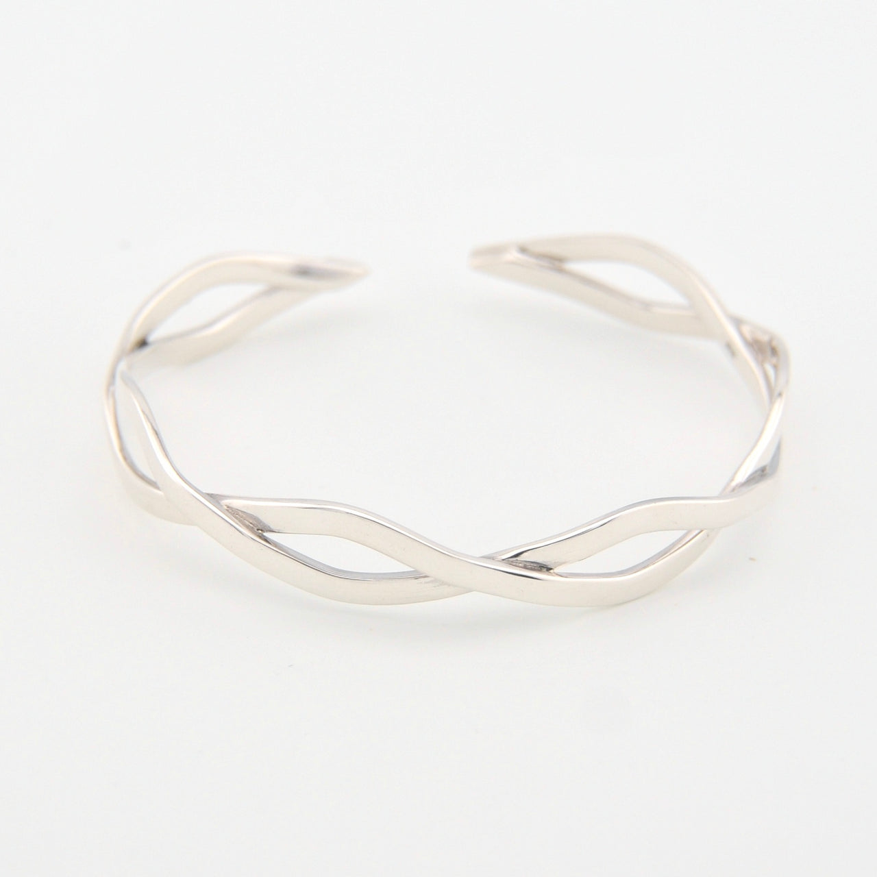 Silver bracelet with a wavy design on a white background