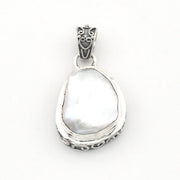 A sterling silver pendant featuring a large, irregular-shaped keshi pearl, set in an ornate silver bezel with a decorative bail.
