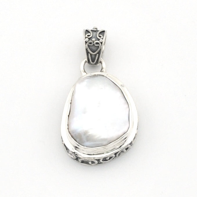 A sterling silver pendant featuring a large, irregular-shaped keshi pearl, set in an ornate silver bezel with a decorative bail.