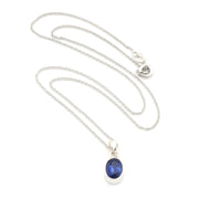 A silver chain necklace with an oval blue gemstone pendant in a silver bezel setting, displayed on a clean white background.