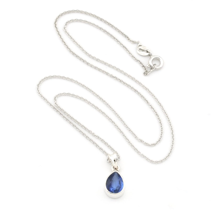 A silver chain necklace with a teardrop-shaped blue gemstone pendant, displayed on a clean white background.