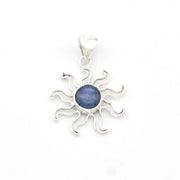 Silver sun-shaped pendant with a blue stone on a white background