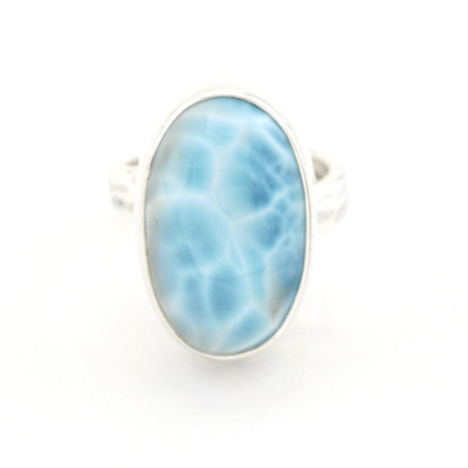 A silver ring featuring an oval-shaped light blue larimar stone with natural white veining, set against a plain white background.