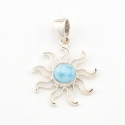 Silver sun-shaped pendant with a blue stone on a white background