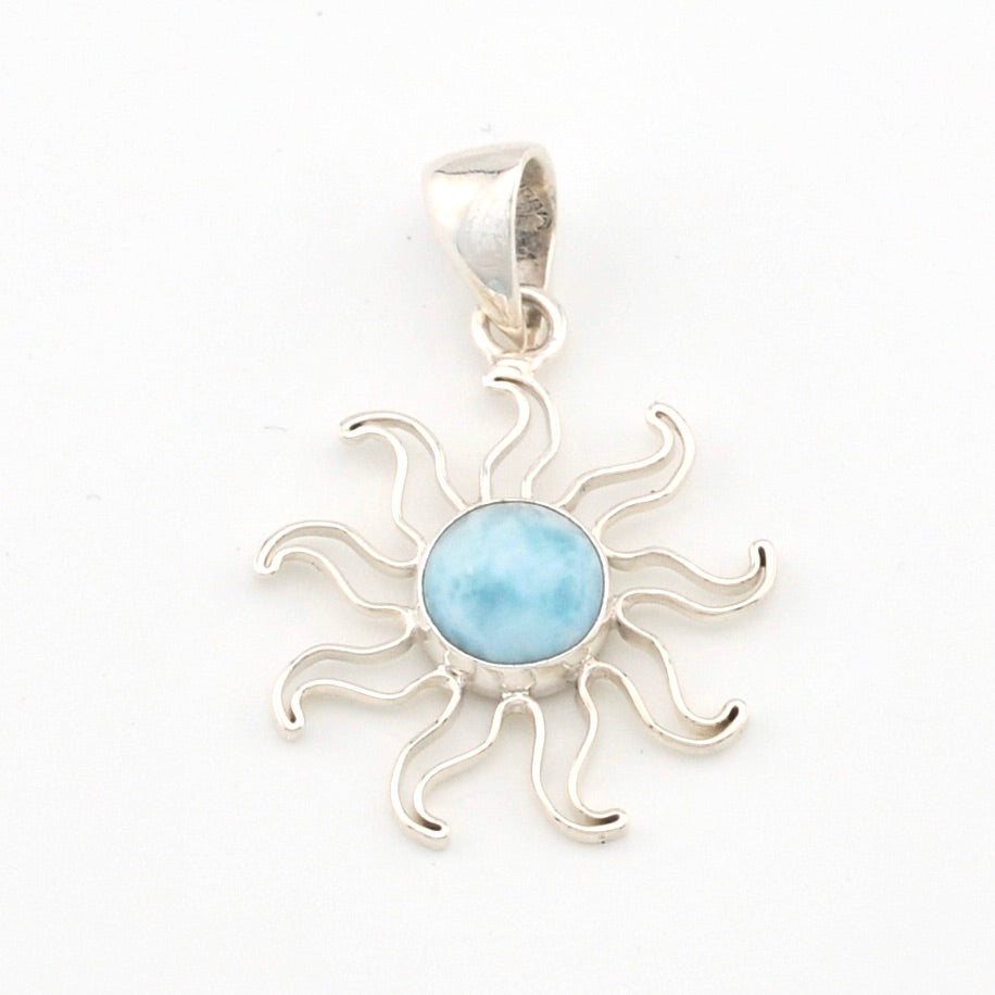 Silver sun-shaped pendant with a blue stone on a white background