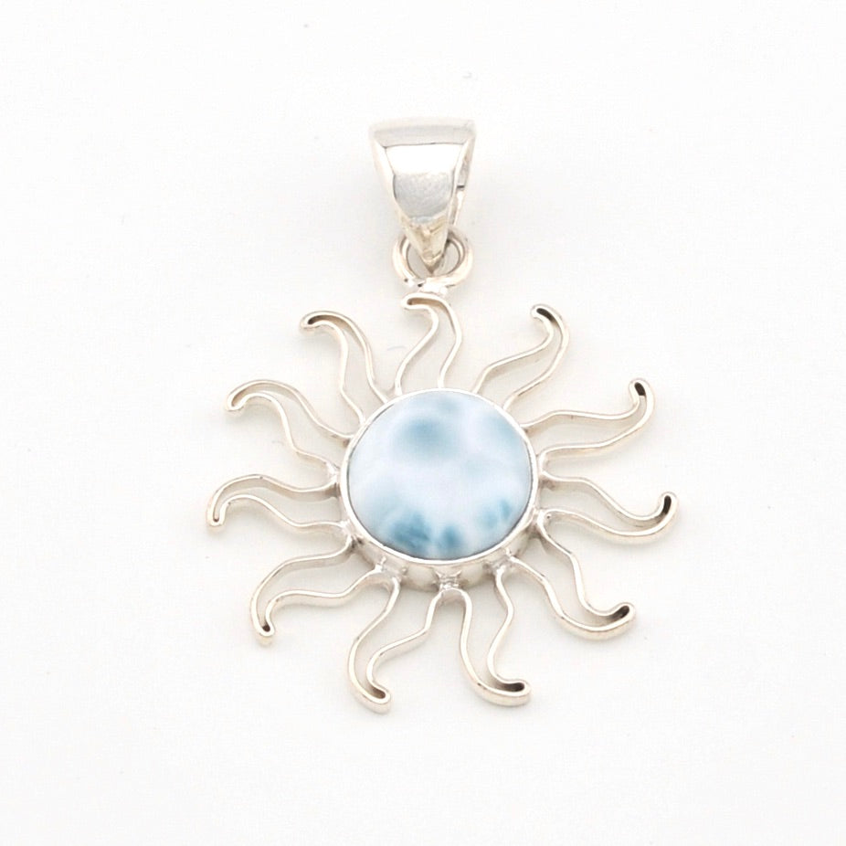 Silver sun-shaped pendant with a blue stone on a white background