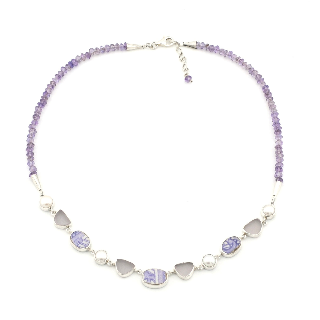 A lavender-toned beaded necklace featuring vintage porcelain, pearls and sea glass, displayed on a clean white background.