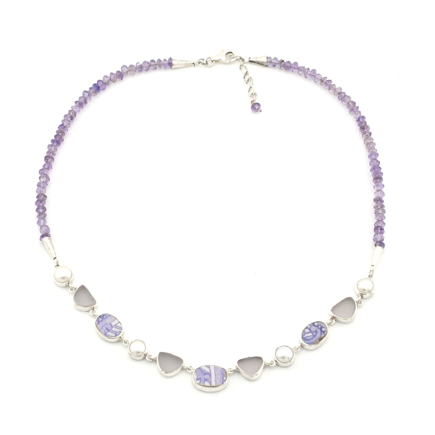 A lavender-toned beaded necklace featuring vintage porcelain, pearls and sea glass, displayed on a clean white background.