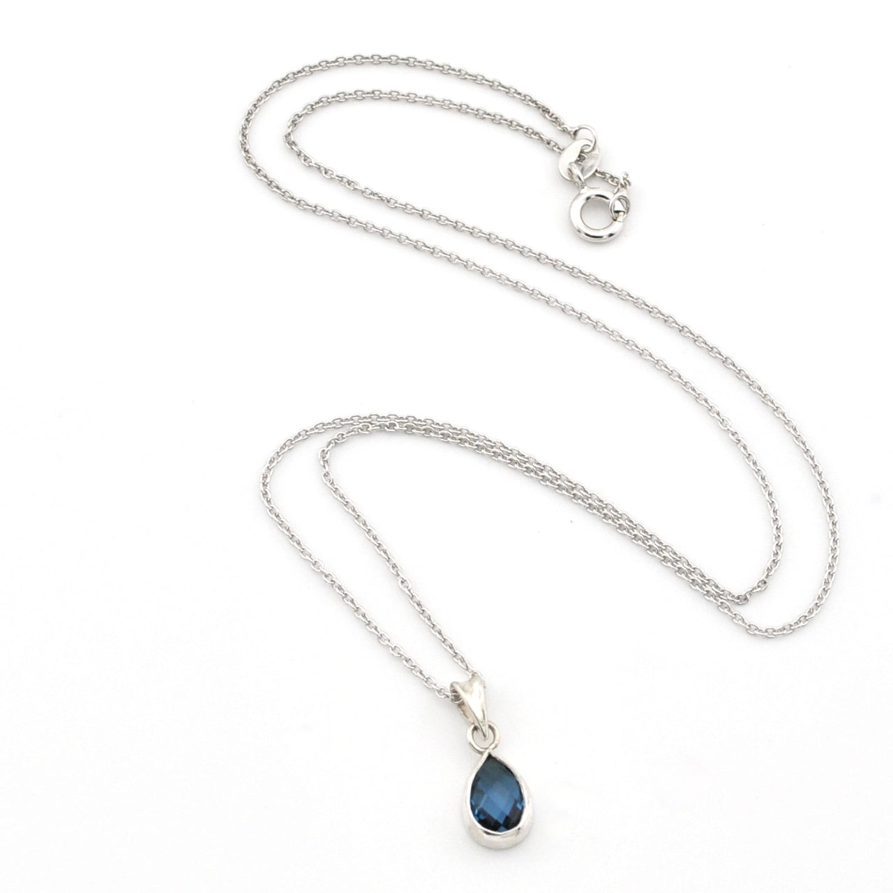 A silver chain necklace with a teardrop-shaped dark blue gemstone pendant, displayed on a clean white background.