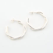 Silver hoop earrings on a light gray background