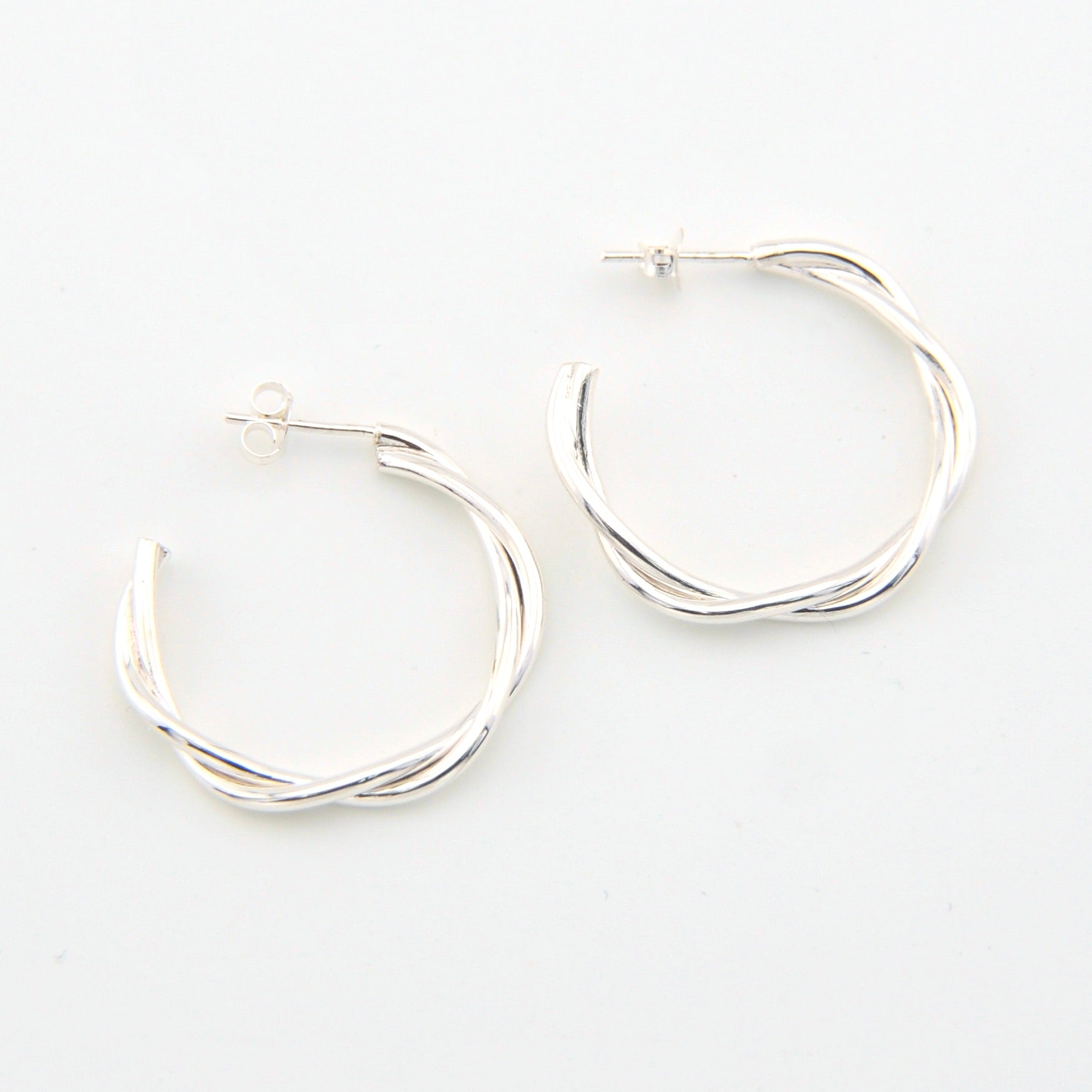 Silver hoop earrings on a light gray background