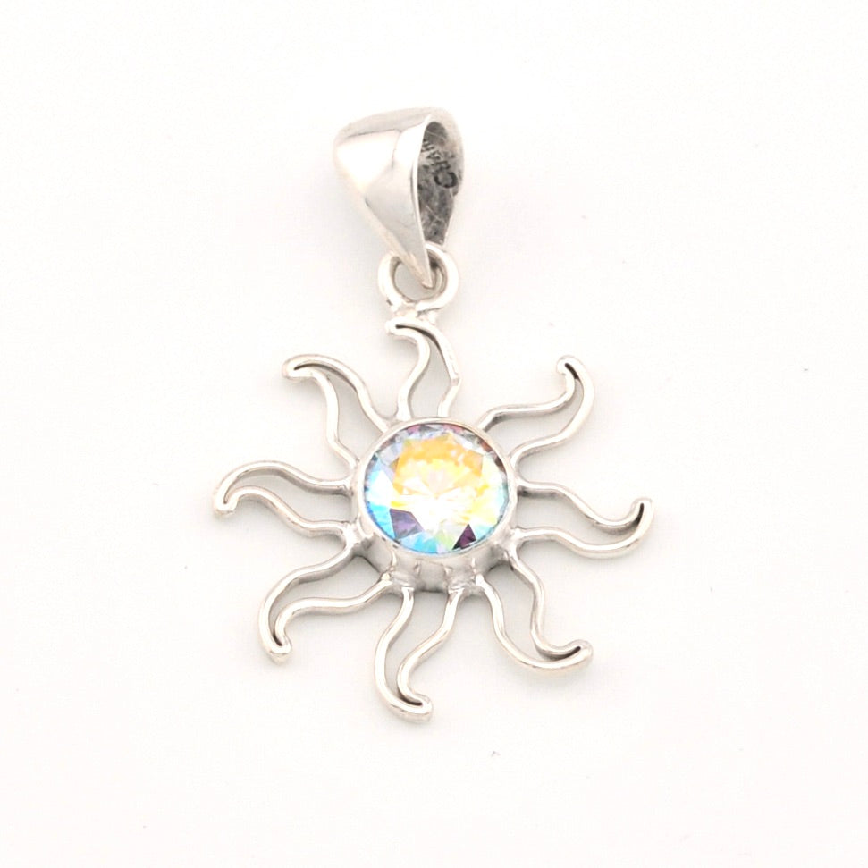 Silver sun-shaped pendant with a colorful gemstone on a white background