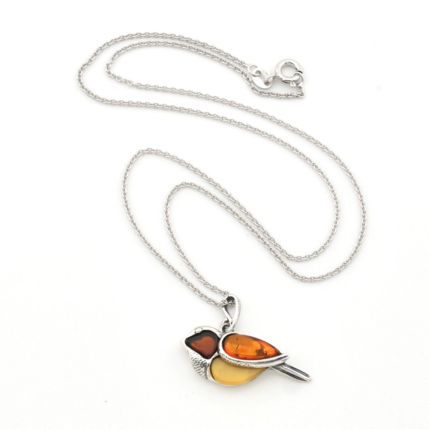 A silver chain necklace featuring a bird pendant made from two amber-colored stones, one dark reddish-brown and one golden-yellow, displayed on a clean white background.