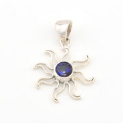 Silver sun-shaped pendant with a blue gemstone on a white background