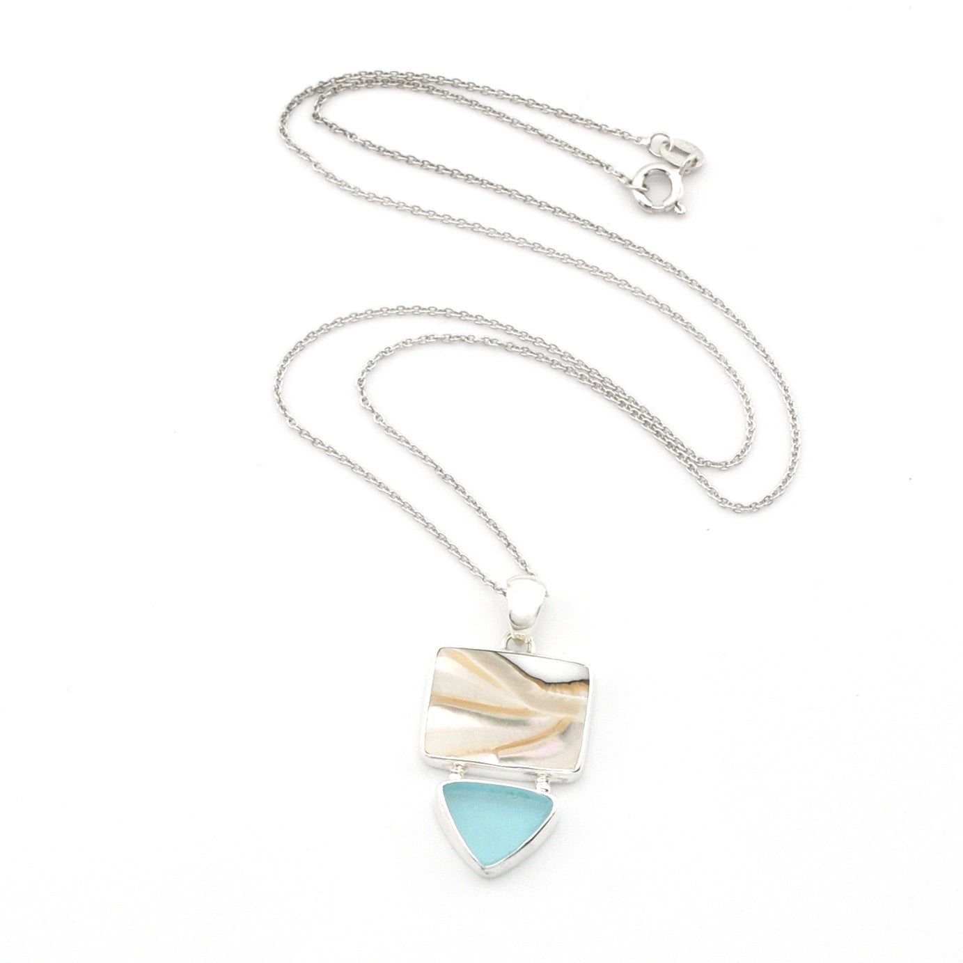 A silver chain necklace with a shell with sea glass pendant, shown open on a white background. 