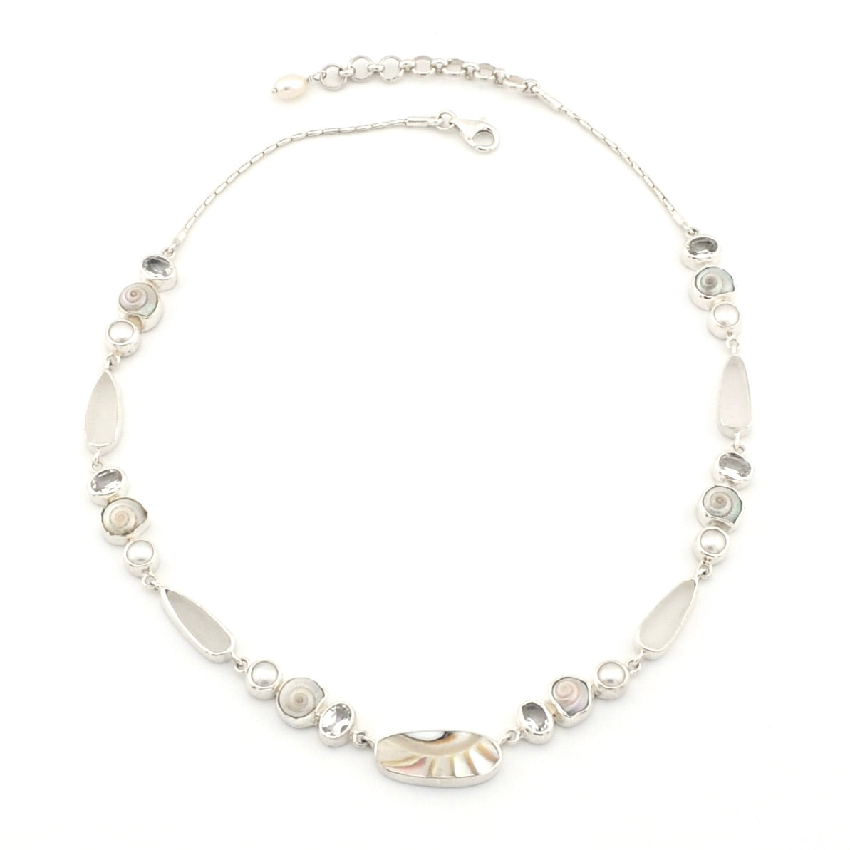 A silver-toned beaded necklace featuring a central polished nautilus shell, oval gems, and smaller round shell and pearls, displayed on a clean white background.
