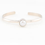 Silver bracelet with a single pearl on a white background