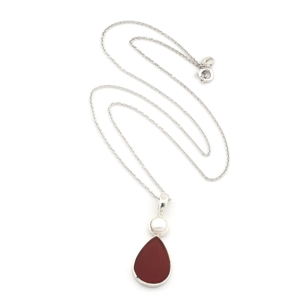 A silver chain necklace featuring a teardrop-shaped dark red pendant with a silver border and a small white pearl accent above it, displayed on a clean white background.