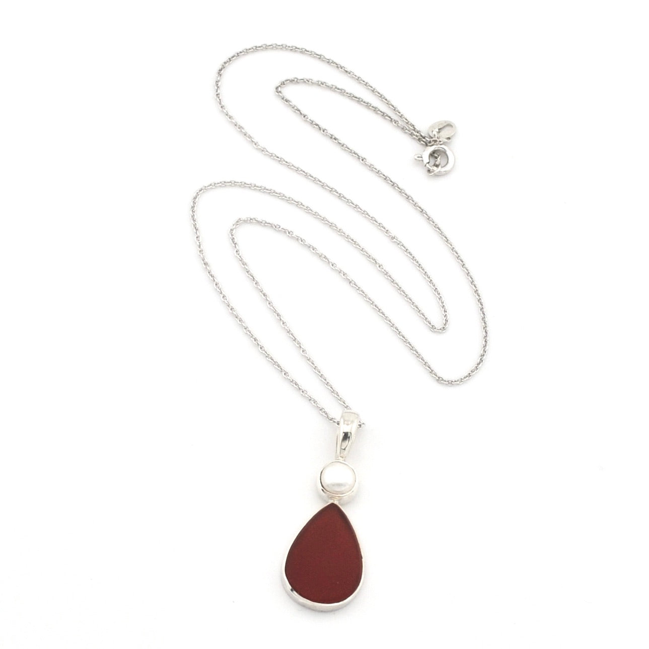 A silver chain necklace featuring a teardrop-shaped dark red pendant with a silver border and a small white pearl accent above it, displayed on a clean white background.