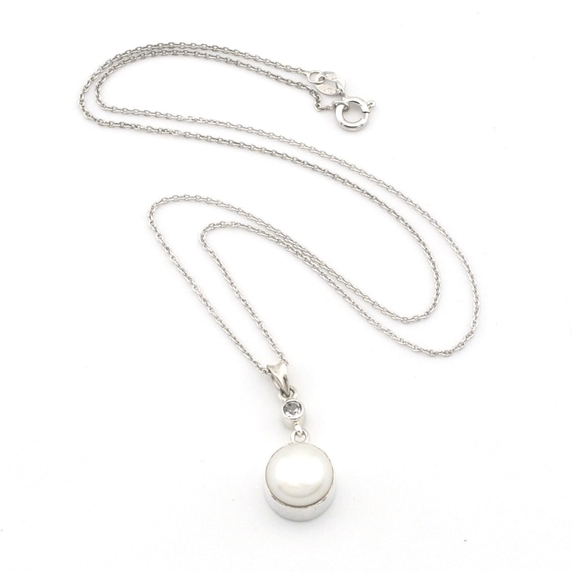 A silver chain necklace with a round white pearl pendant in a polished silver bezel setting, displayed on a clean white background.
