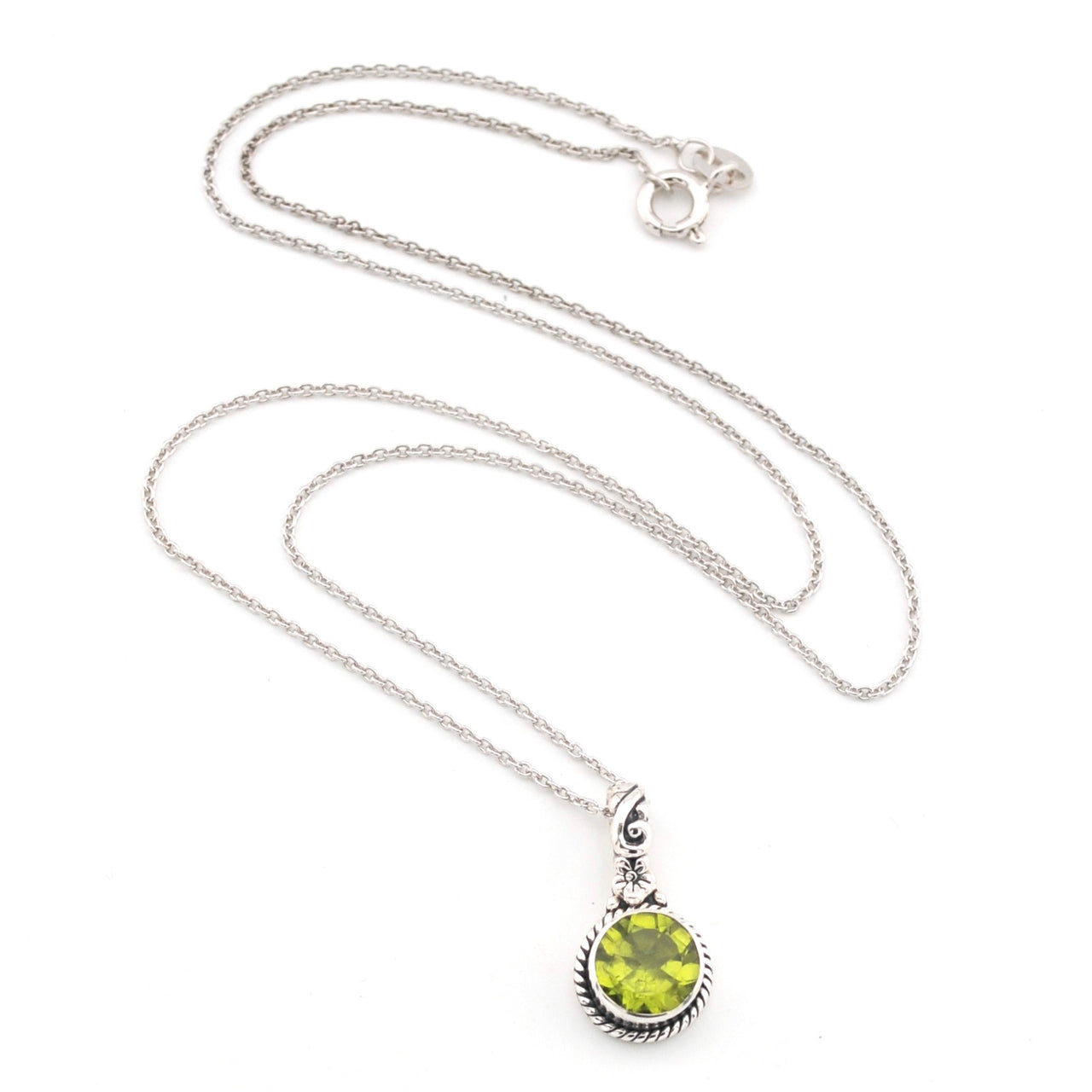 Silver necklace with a green peridot pendant on a white background