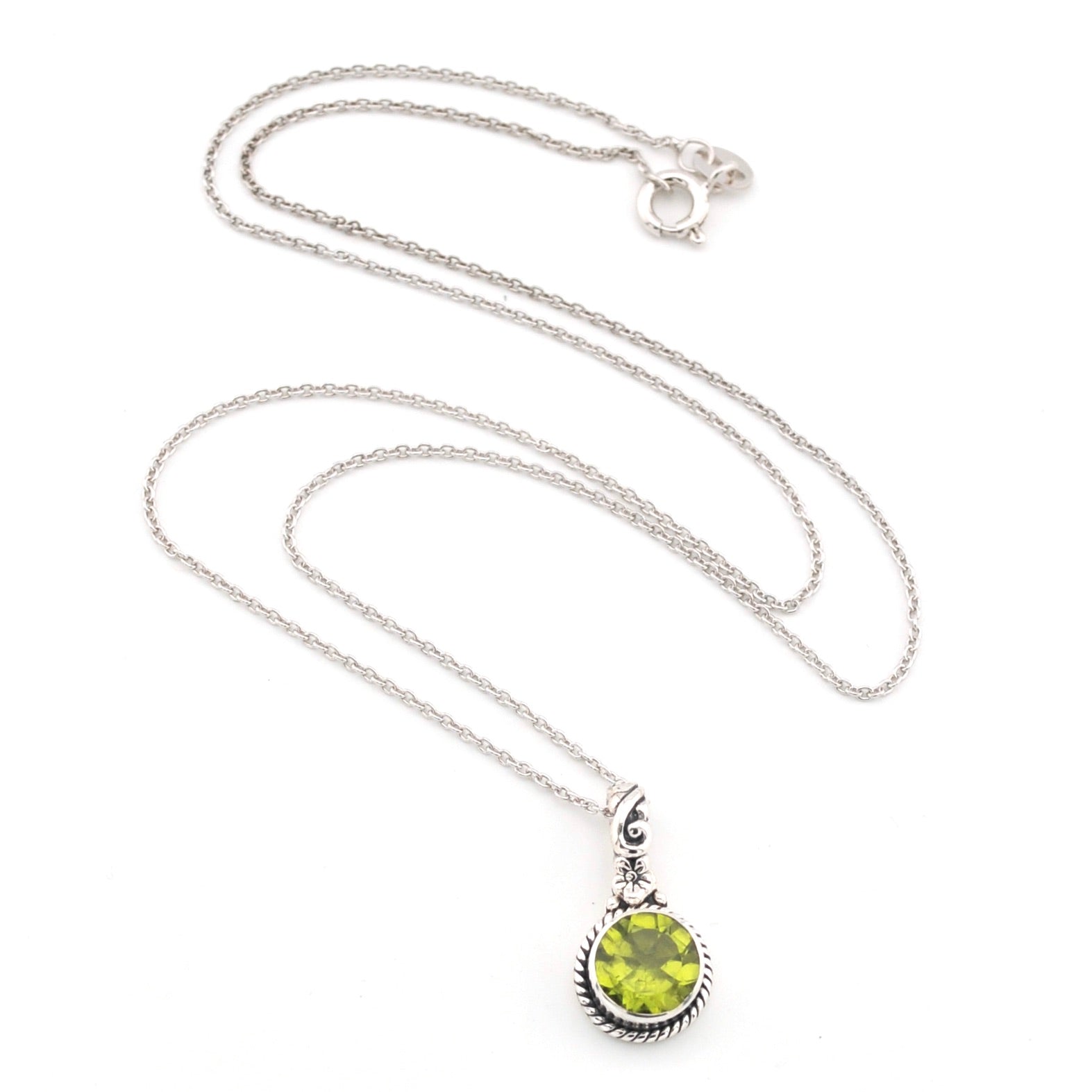 Silver necklace with a green peridot pendant on a white background