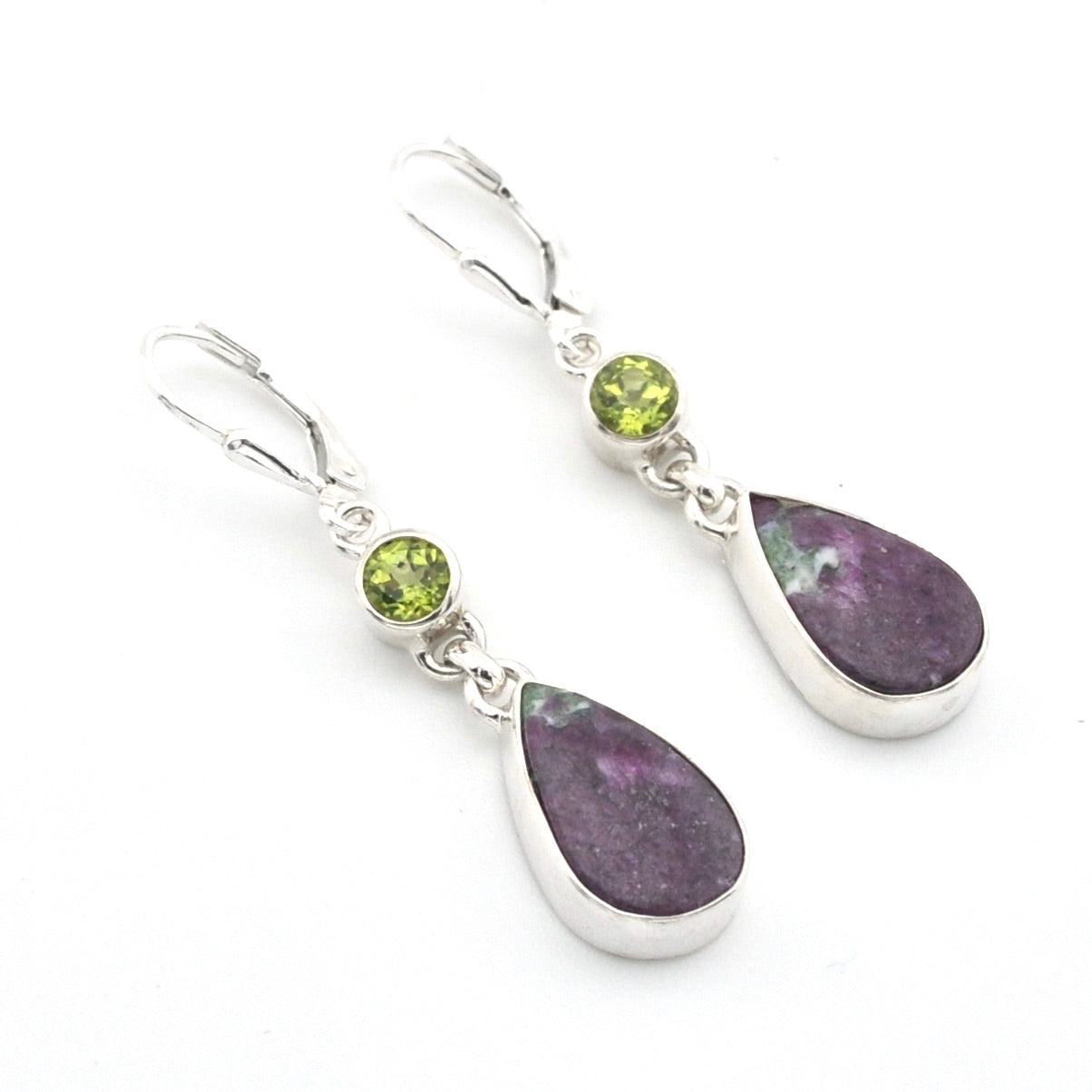 A pair of sterling silver drop earrings featuring oval-cut purple ruby zoisite stones and round green peridot accent stones, set against a plain white background.