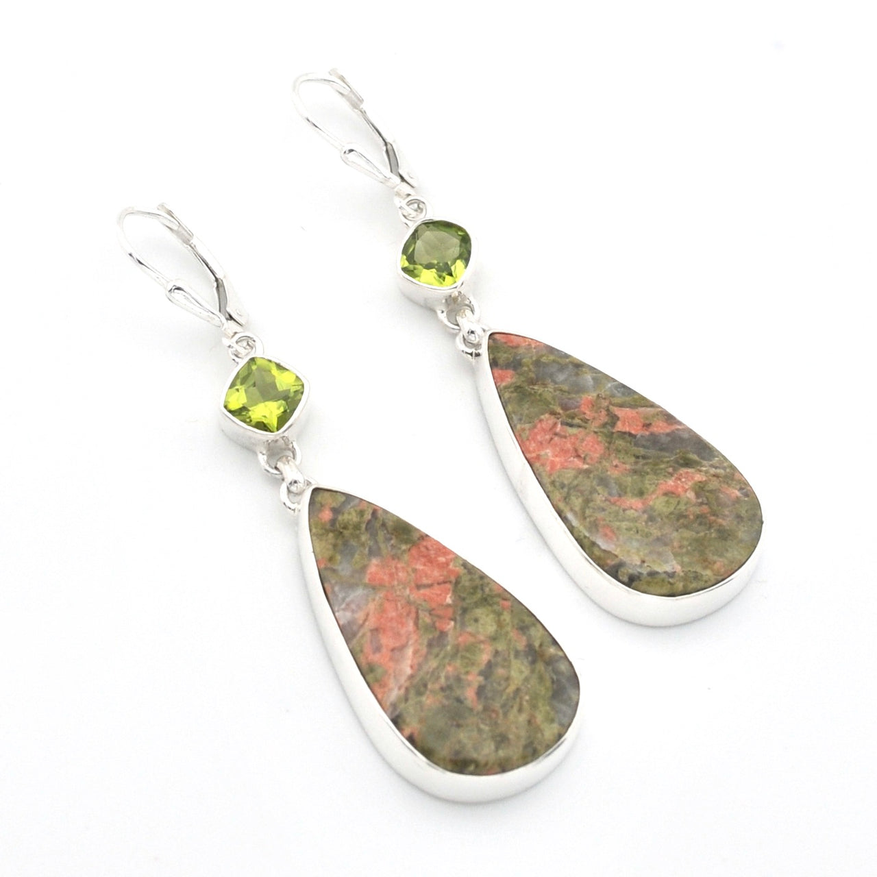 A pair of silver dangle earrings featuring teardrop-shaped natural stone pendants with green, brown, and pink marbled patterns, accented by small square green gemstones and leverback hooks, shown on a white background.