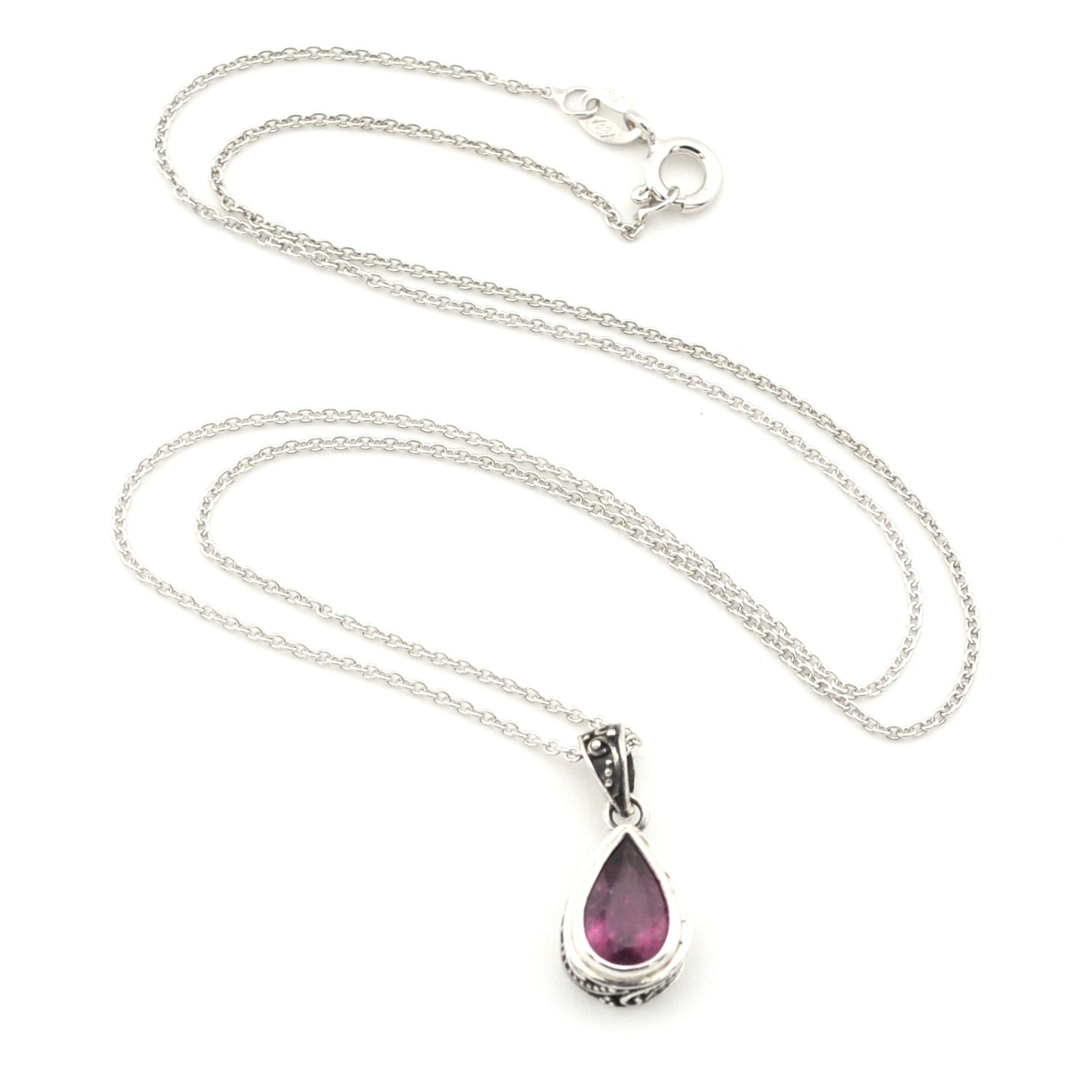 A silver teardrop pendant necklace featuring a faceted purple gemstone, displayed on a clean white background.