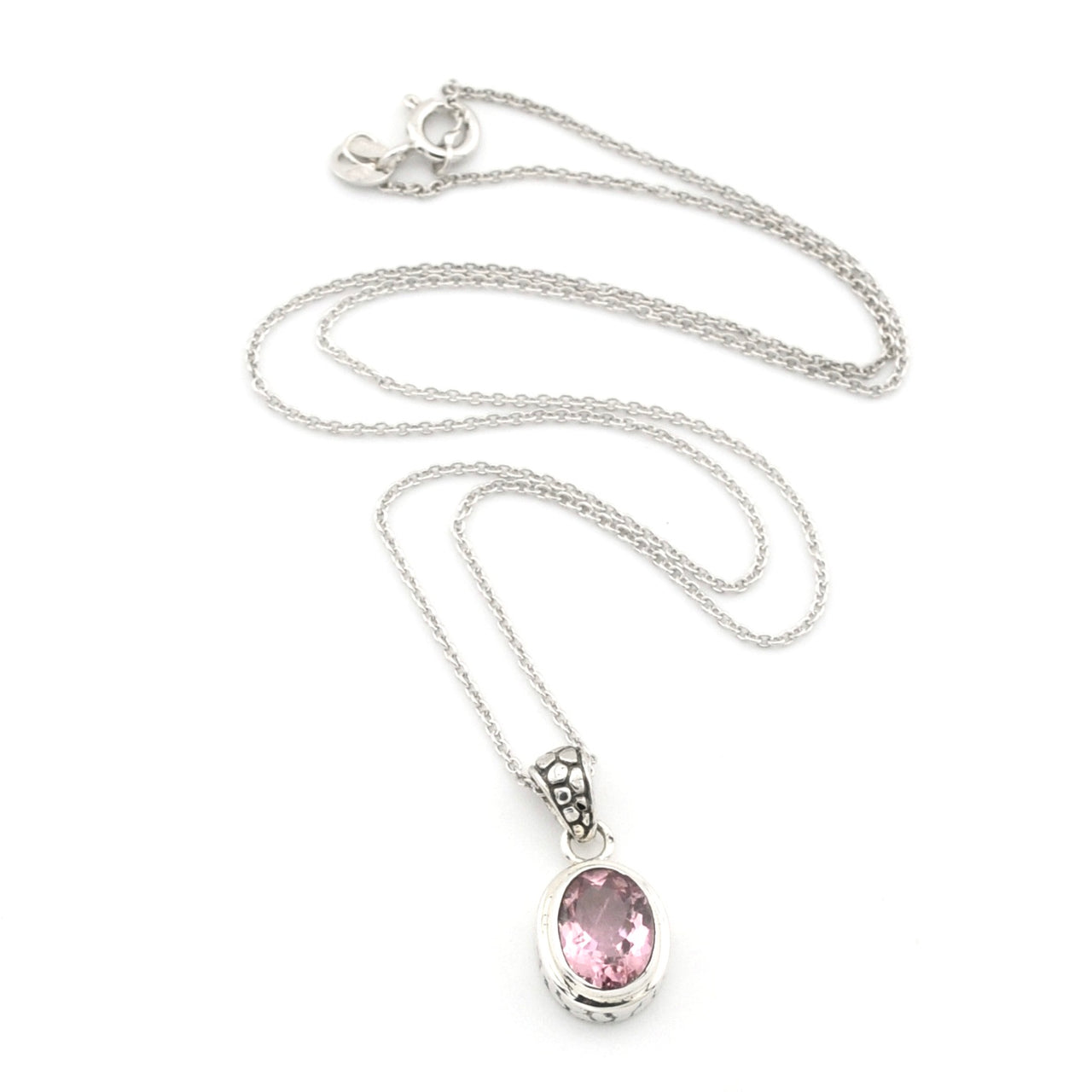 A silver chain necklace with an oval pink gemstone pendant, displayed on a clean white background.
