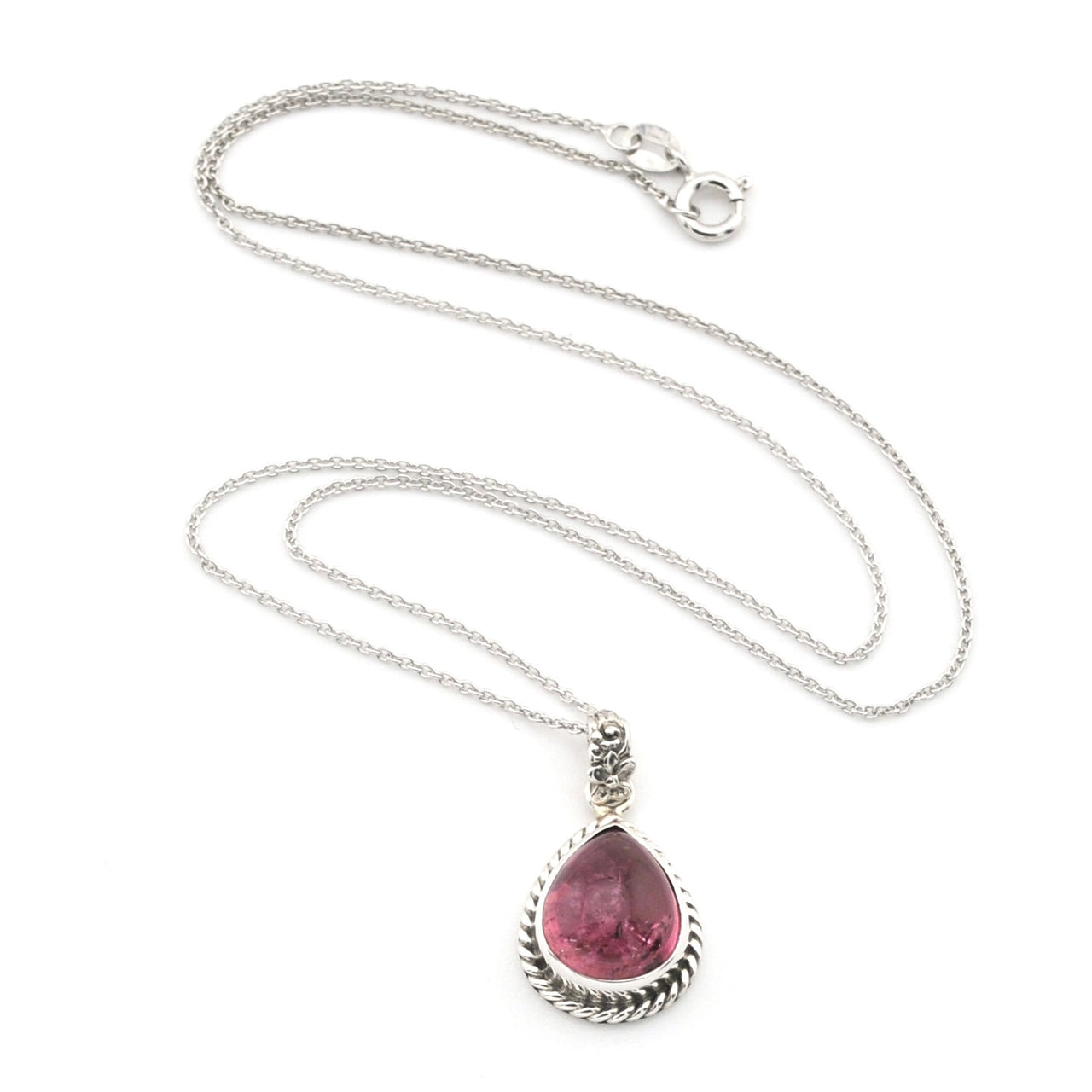 A silver necklace featuring a teardrop-shaped pink gemstone pendant in a textured bezel setting, displayed on a clean white background.
