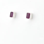 A pair of silver stud earrings with small rectangular purple gemstones, shown on a plain white background.