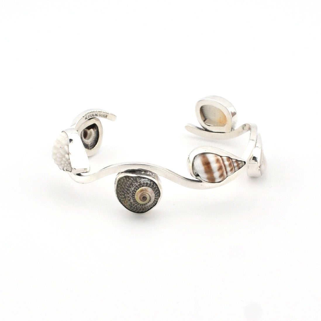 Silver cuff bracelet with shell-like embellishments on a white background