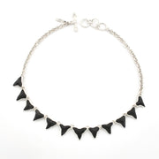 Silver necklace with 12 fossil shark teeth on white background.