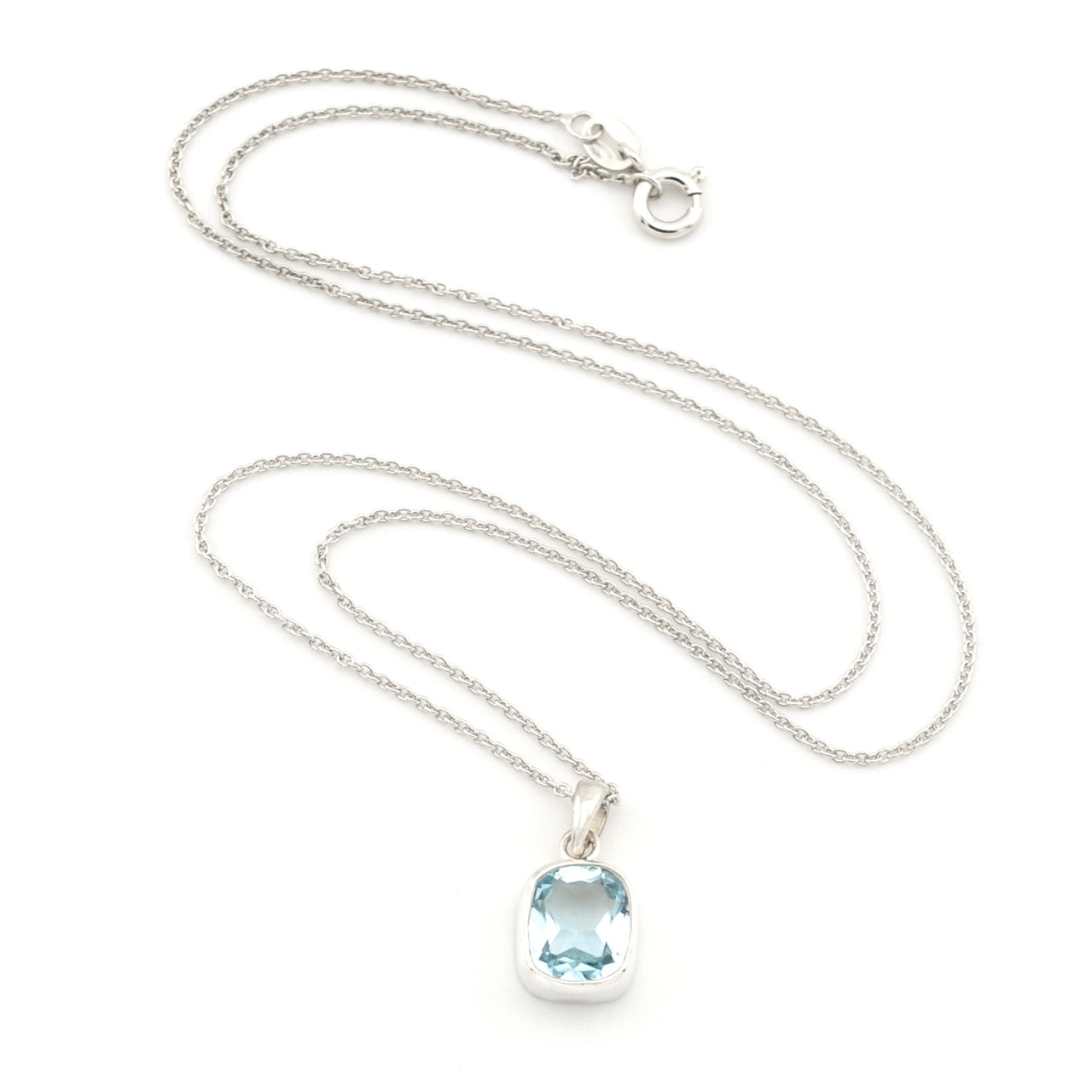 A silver chain necklace with a silver bezel-set oval light blue gemstone pendant, displayed on a clean white background.