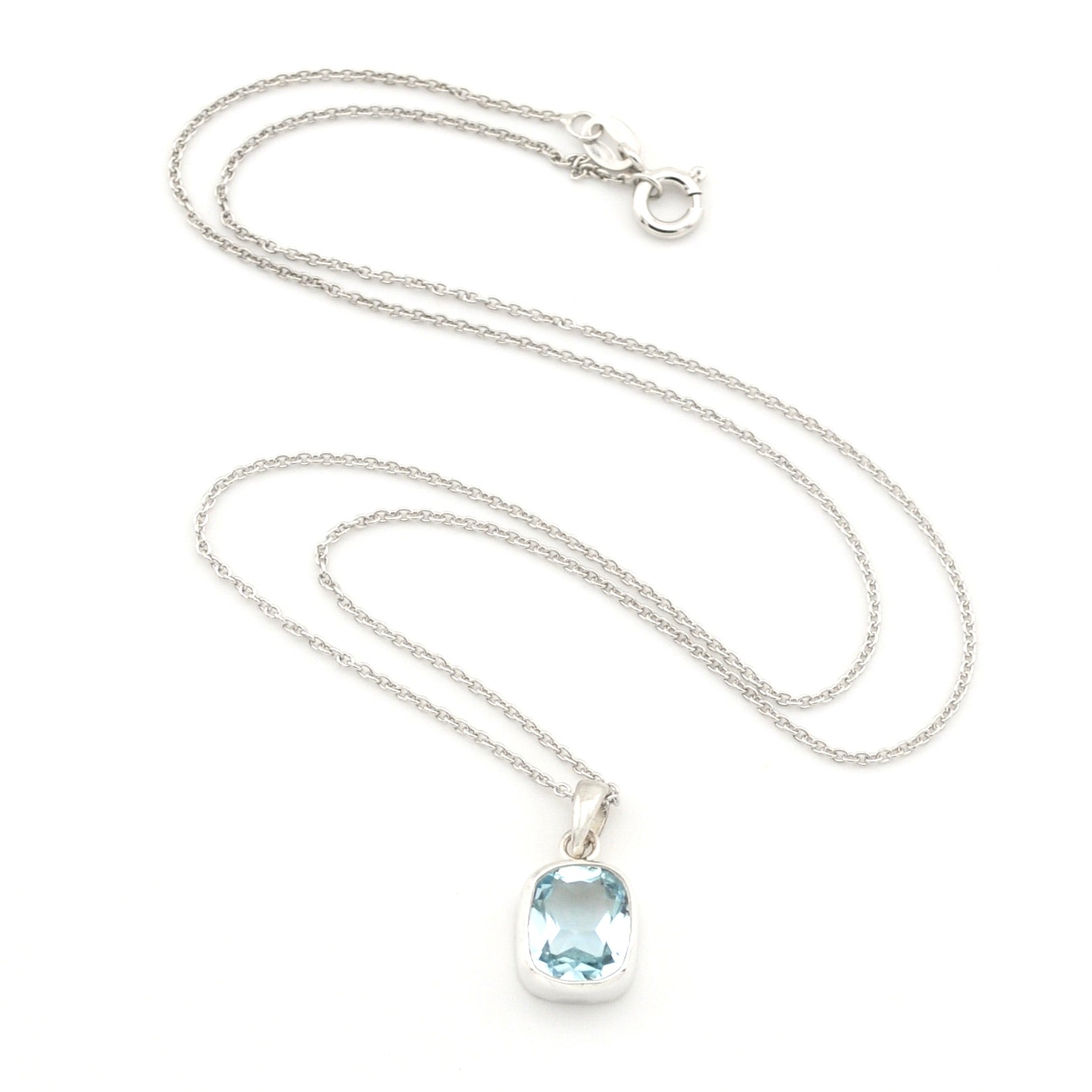 A silver chain necklace with a silver bezel-set oval light blue gemstone pendant, displayed on a clean white background.