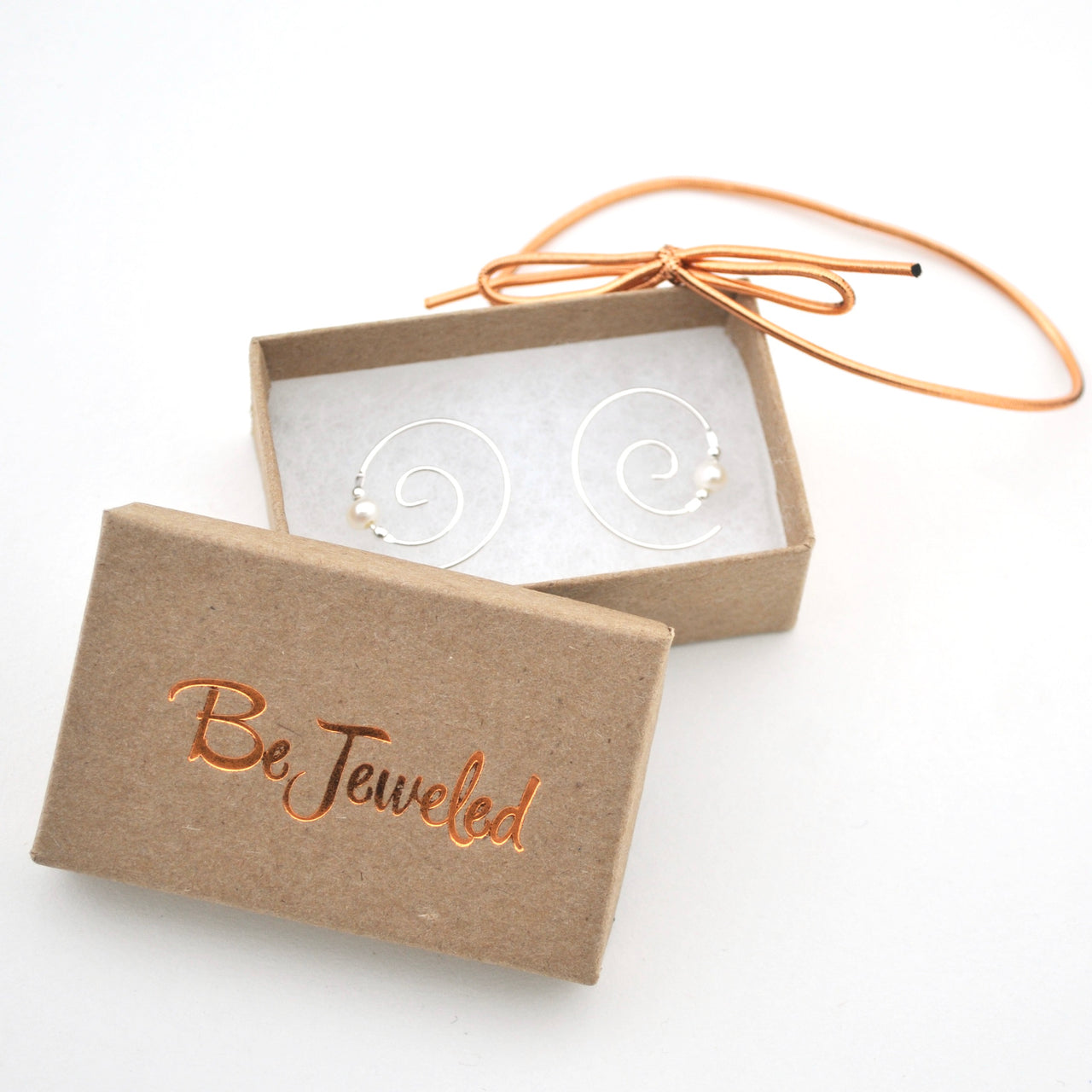 Gold hoop earrings in a 'Be Jeweled' box on a white background