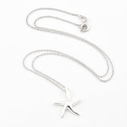 A silver starfish pendant necklace on a delicate silver chain, displayed on a clean white background.