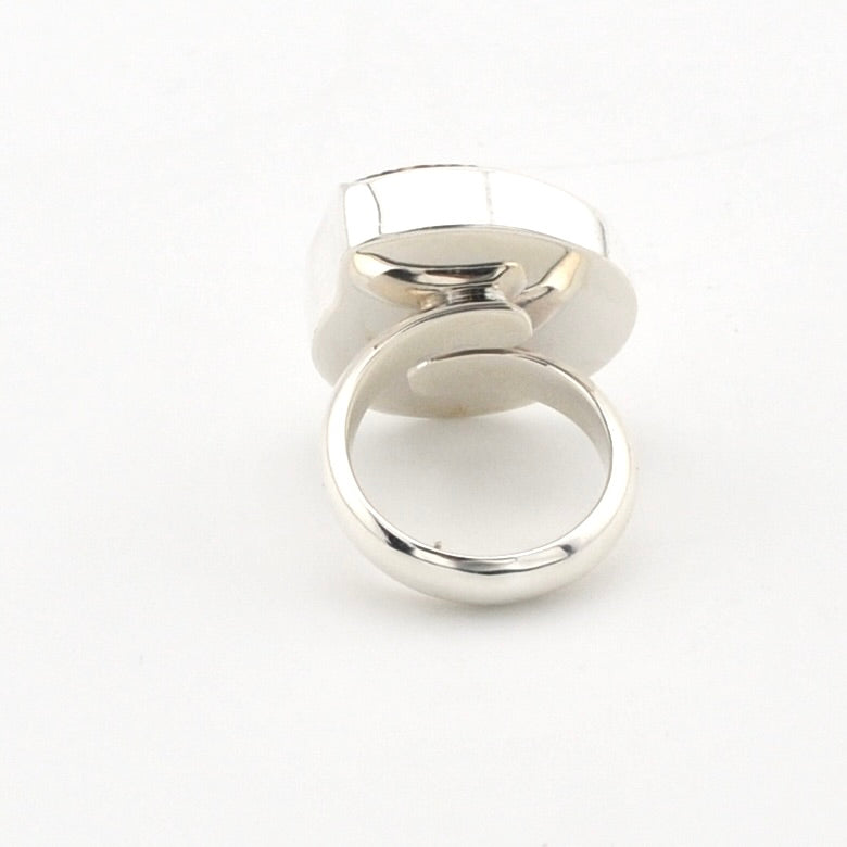 A polished silver-toned ring with a geometric, multi-faceted top and a smooth circular band, shown on a plain white background.