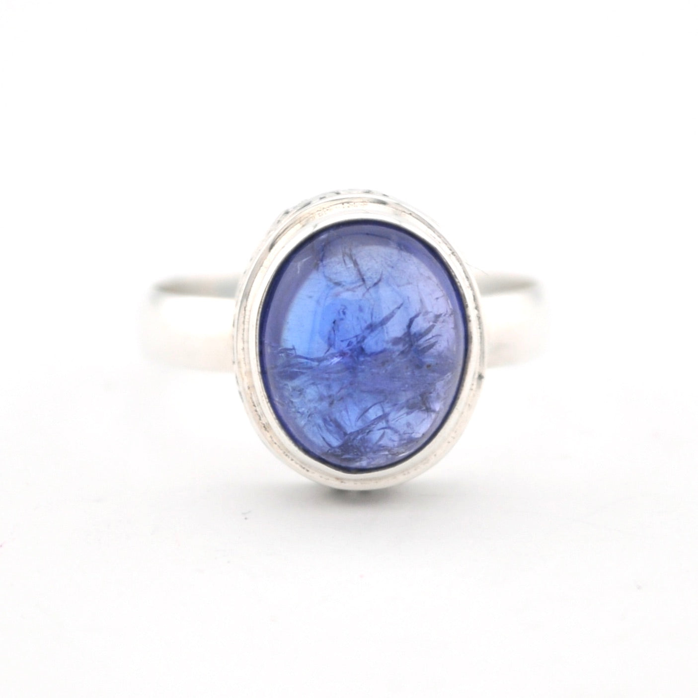 Silver ring with a blue stone on a white background