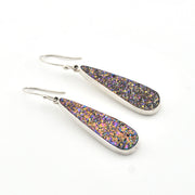 Teardrop-shaped earrings with purple and gold glitter on a white background