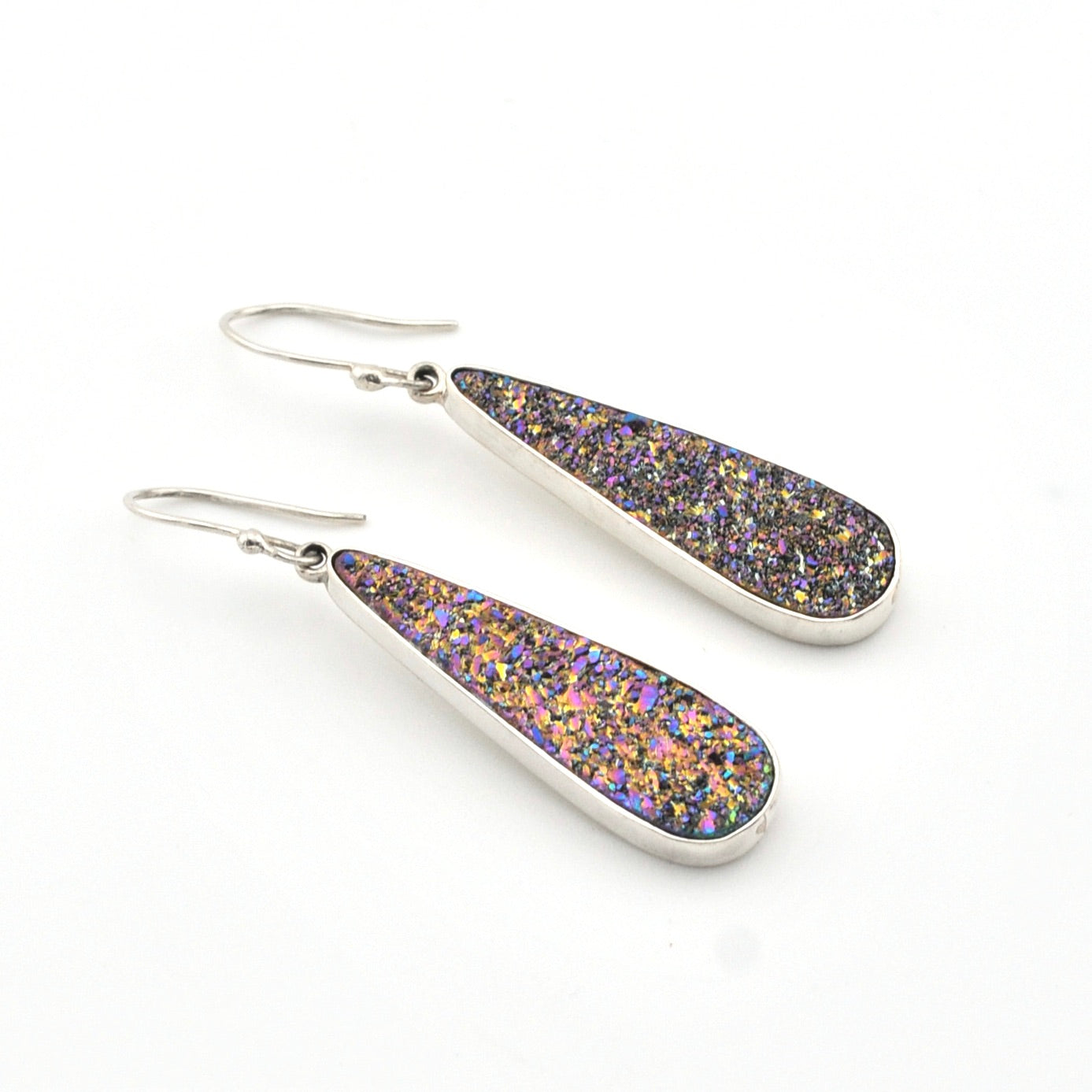 Teardrop-shaped earrings with purple and gold glitter on a white background