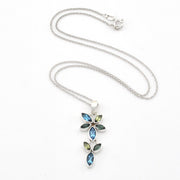 A silver-tone floral pendant necklace featuring marquise-cut blue and olive-green stones, displayed on a clean white background.