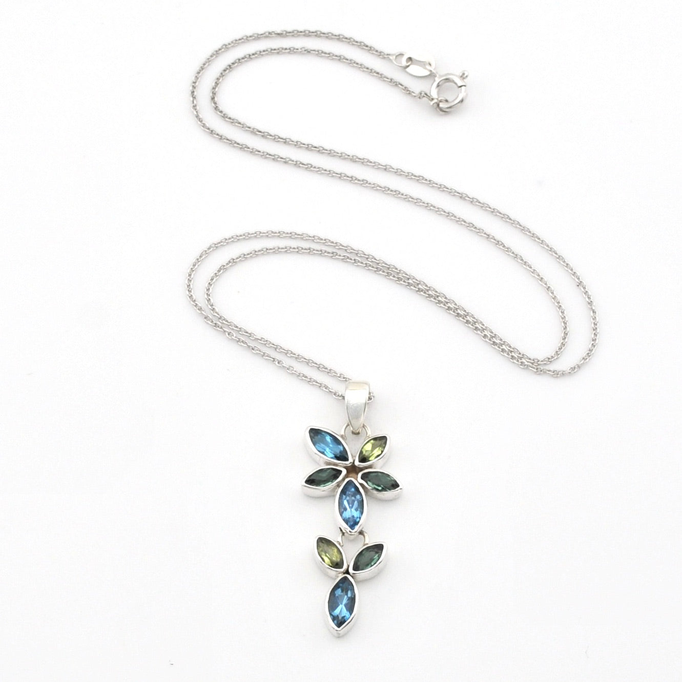 A silver-tone floral pendant necklace featuring marquise-cut blue and olive-green stones, displayed on a clean white background.
