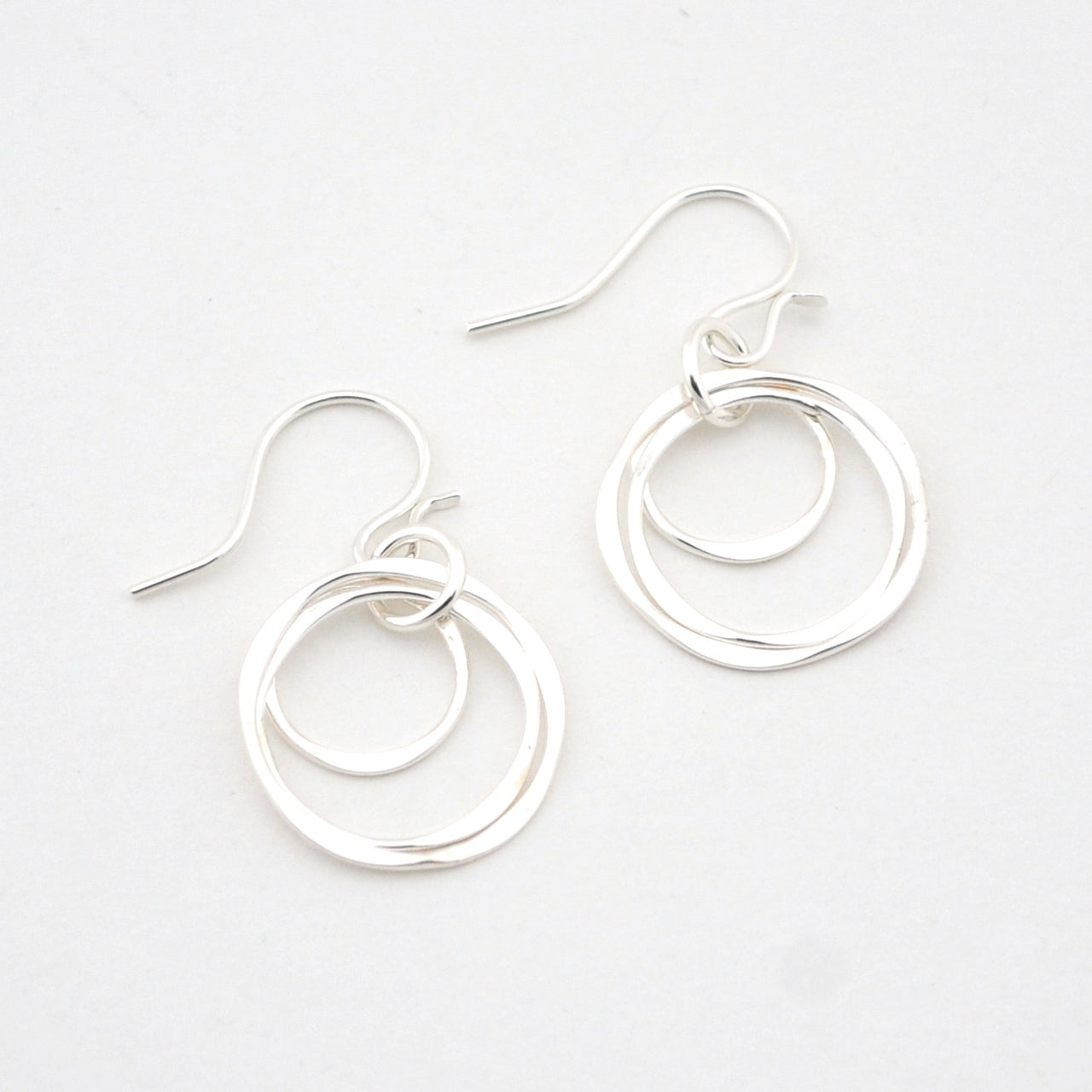Pair of silver hoop earrings on a white background