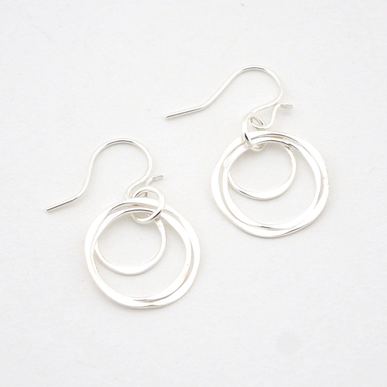 Pair of silver hoop earrings on a white background
