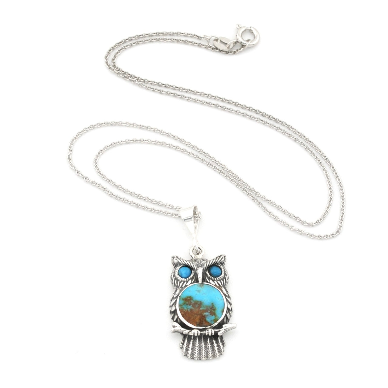 A sterling silver owl pendant necklace featuring a turquoise and brown stone face with blue stone eyes, displayed on a clean white background.