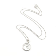 Silver necklace with a wave pendant on a white background