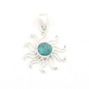 A sterling silver sunburst pendant featuring a round turquoise cabochon in the center, set against a plain white background.